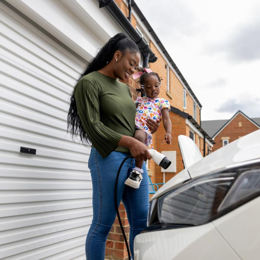 Free stock photo of a resident charging an electric vehicle outside a home